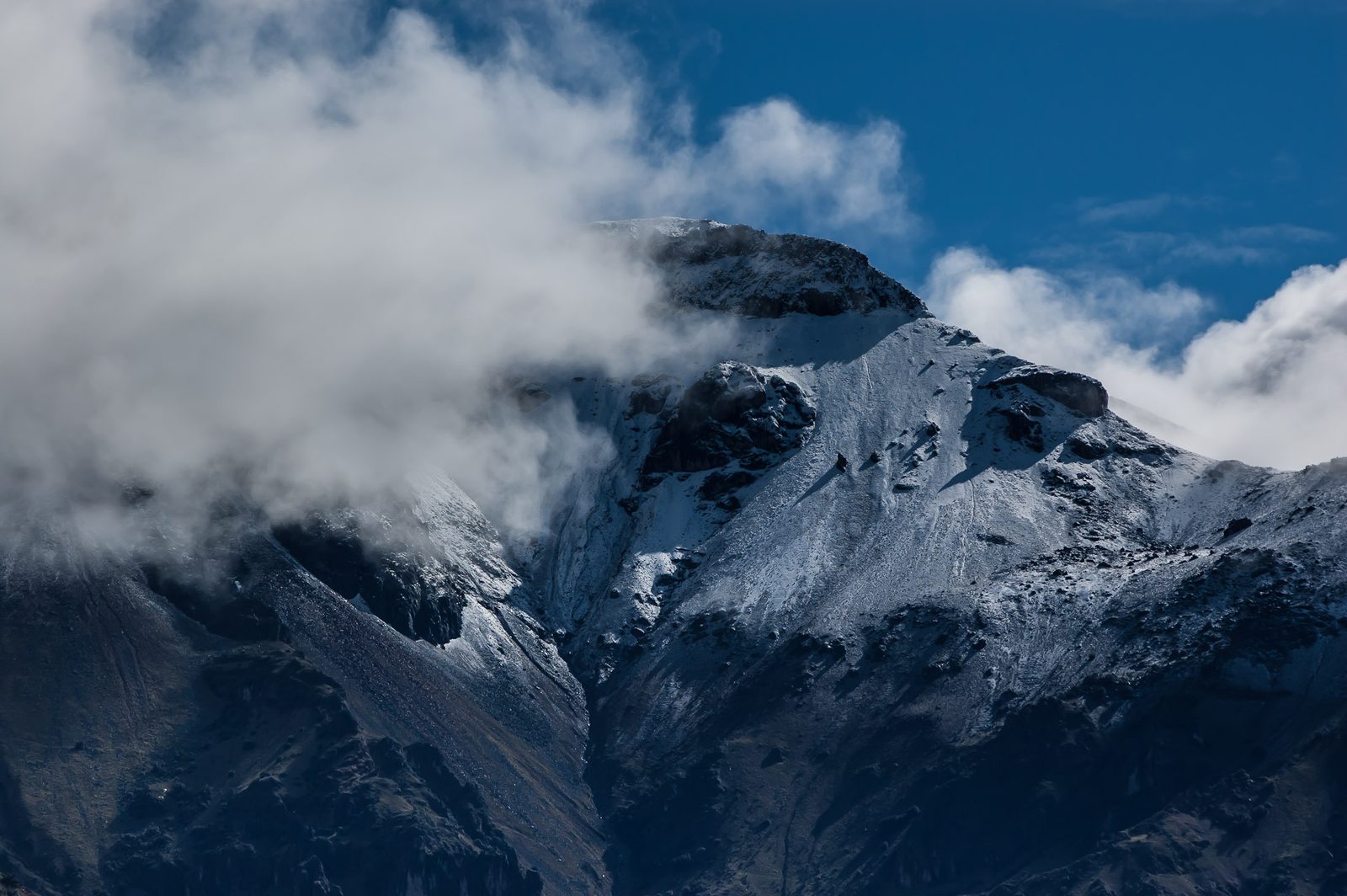 A snow-covered Andean peak under cloud
